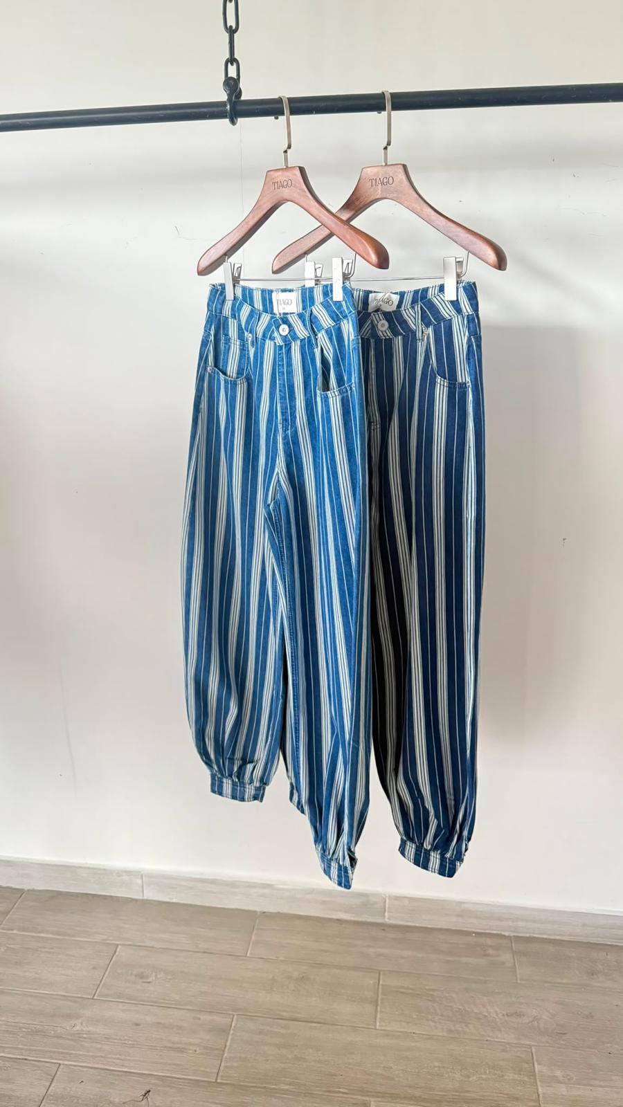 מכנס ג'ינס מונקו מכנסי ג'ינס מפוספסים, גזרה רפויה עם שרוך במכפלת, תלויים על קולבים, מבט קדמי.